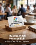 Kafe masasında ahşap standta duran Google Maps NFC yorum kartı